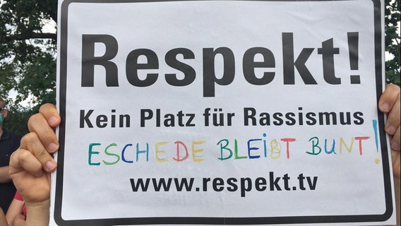 Jemand hält ein Schild mit der Aufschrift "Respekt" Kein Platz für Rassismus. Eschede bleibt bunt" hoch. © Netzwerk Südheide gegen Rechtsextremismus Foto: Wilfried Manneke