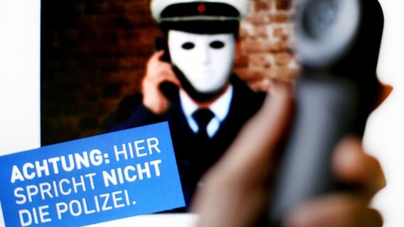 Ein Telefonhörer ist vor einem Plakat der Polizei mit der Aufschrift "Achtung: Hier spricht NICHT die Polizei" zu sehen. © dpa-Bildfunk Foto: Martin Gerten/dpa