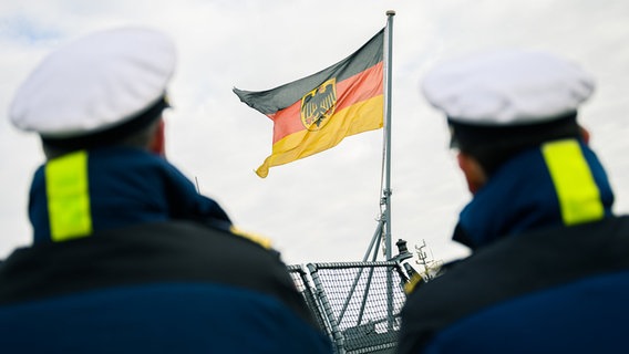 Zwei Marinesoldaten stehen am Hafen des Marinestützpunktes Wilhelmshaven und beobachten die Rückkehr der Fregatte "Hamburg". © dpa-Bildfunk Foto: Mohssen Assanimoghaddam/dpa