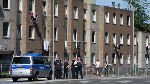 Einsatzkräfte der Polizei stehen vor einem unter Quarantäne gestellten Wohngebäude. © dpa-Bildfunk Foto: Swen Pförtner/dpa