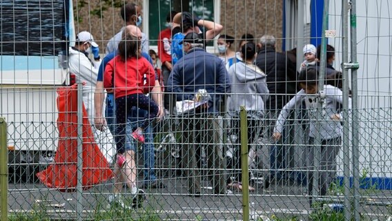 Bewohner stehen vor einem unter Quarantäne gestellten Wohnhaus. © dpa-Bildfunk Foto: Swen Pförtner/dpa