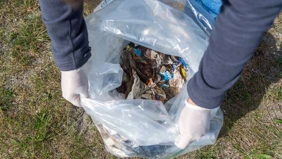 Ein Blick in eine Mülltüte mit aufgesammelten Müll. © dpa-Bildfunk Foto: Benjamin Nolte/dpa