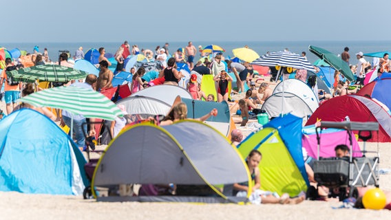 Zahlreiche Strandbesucher sind bei sommerlichen Temperaturen am Nordseestrand von Schillig. © dpa-Bildfunk Foto: Mohssen Assanimoghaddam/dpa