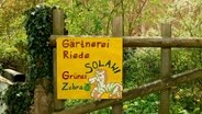 Ein selbst gemaltes Schild mit der Aufschrift: Gärtnerei Riede, Grünes Zebra © NDR Foto: Leonie Jost