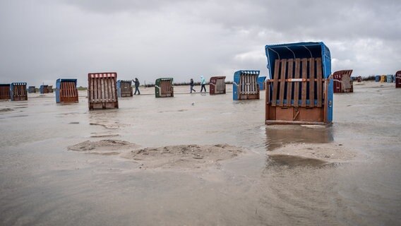 Dunkle Wolken ziehen über die Strandkörbe am Strand von Neßmersiel. © dpa-Bildfunk Foto: Sina Schuldt/dpa