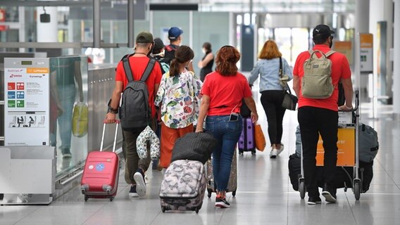 Reisende mit Rollkoffern an einem Flughafen. (Sybolbild) © picture alliance / Sven Simon Foto: Frank Hoermann