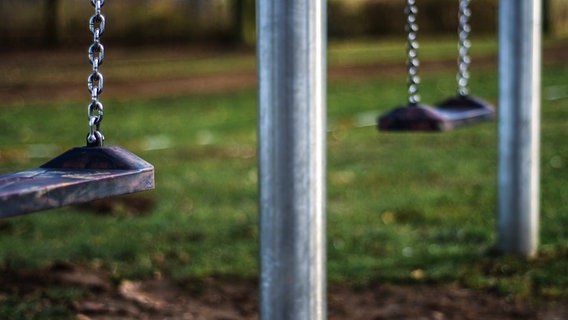 Zwei Schaukeln auf einem Spielplatz © photocase Foto: Thomas Ruppel