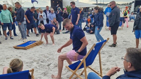 Eine Gruppe baut Strandstühle auf. © NDR Foto: Jannik Wölffel