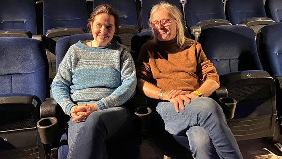 Anna und Wolf Malten sitzen nebeneinander auf blauen Zuschauersitzen im Theater. © NDR Foto: Linda Ebener