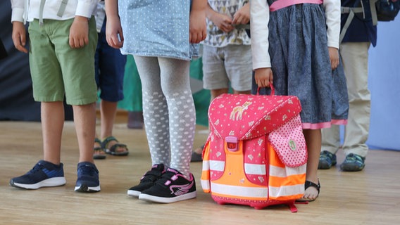 Schulkinder mit stehen wartend in einer Reihe. © picture alliance Foto: Mascha Brichta