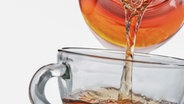 Tee wird aus einer Teekanne aus Glas in eine gläserne Teetasse gegossen. © Colourbox Foto: Dima Sobko