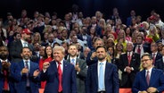Der republikanische Präsidentschaftskandidat und ehemalige US-Präsident Donald Trump und der republikanische Vizepräsidentschaftskandidat J.D. Vance nach ihrer Nominierung auf dem Parteitag in Milwaukee. Trump ballt die Faust. © dpa-Bildfunk/AP Foto: Evan Vucci
