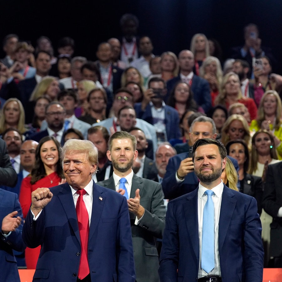 Der republikanische Präsidentschaftskandidat und ehemalige US-Präsident Donald Trump und der republikanische Vizepräsidentschaftskandidat J.D. Vance nach ihrer Nominierung auf dem Parteitag in Milwaukee. Trump ballt die Faust. © dpa-Bildfunk/AP Foto: Evan Vucci