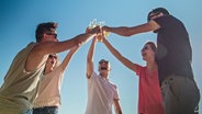 Eine Gruppe junger Menschen stoßen mit Bier an. © Colourbox Foto: -