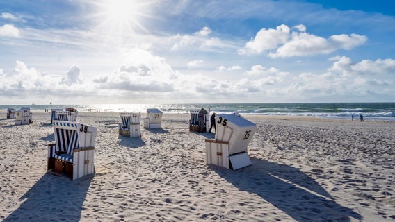 An einem leeren Strand stehen Strandkörbe. © picture alliance / imageBROKER Foto: Moritz Wolf