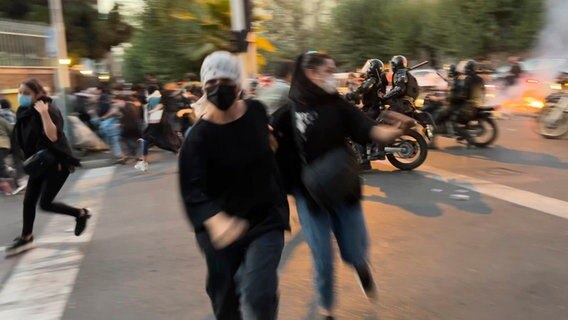 Frauen fliehen bei Protesten in der iranischen Hauptstadt Teheran vor der Polizei. © AP/dpa 