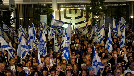 Israelis protestieren in Tel Aviv gegen die Pläne der Regierung. © dpa Foto: Ohad Zwigenberg/AP