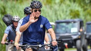 US-Präsident Joe Biden auf einem Fahrrad im Gordon's Pond State Park in Rehoboth Beach,
Delaware © AFP Foto: NICHOLAS KAMM