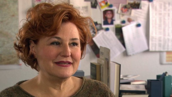Sabine Rückert (58), Mitglied der Chefredaktion der "Zeit", wird in ihrem Büro interviewt. Sie trägt einen Pulli und hat einen Pagenschnitt mit gewellten, brünetten Haaren. © NDR 