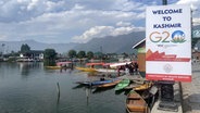 der Dal Lake in Kashmir mit einem Plakaat zum G20 Arbeitsgruppe Tourismus © NDR Foto: Peter Hornung