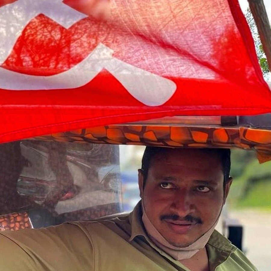 Ein Mann in Indien hält eine rote Fahne hoch © NDR Foto: Peter Hornung