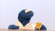 Krümel betrachtet einen Keks © NDR/ Sesame workshop 