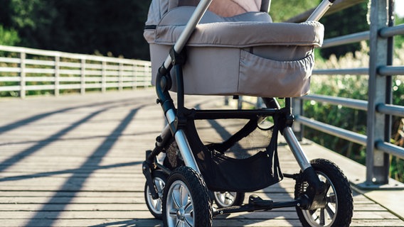 Ein Kinderwagen wird über eine Brücke geschoben. © fotolia.com Foto: tataks