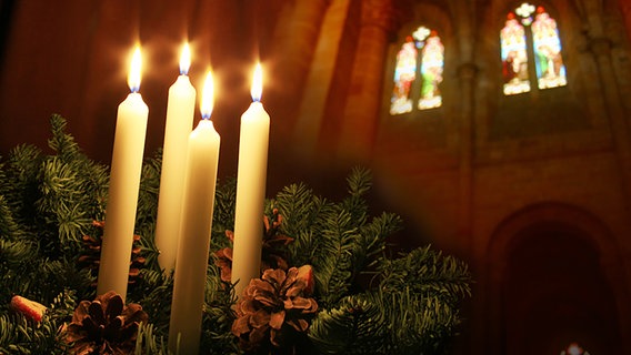 Bildmontage: Adventsgesteck vor Kirchenfenster © Fotolia.com Foto: corabelli, vansteenwinckel