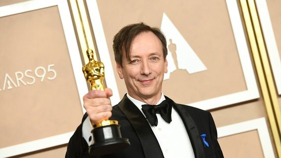 Komponist Volker Bertelmann alias Hauschka hält eine Oscar-Statuette in der Hand. © picture alliance / ZUMAPRESS.com Foto: Kevin Sullivan