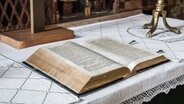 Eine aufgeschlagene Bibel liegt auf einem Altar. © Kirche im NDR Foto: Christine Raczka