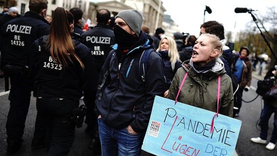 Teilnehmer einer Demonstration gegen die Corona-Einschränkungen der Bundesregierung protestieren vor dem Brandenburger Tor und halten ein Schild mit der Aufschrift "Pandemie der Lügen". © dpa-Bildfunk Foto: Kay Nietfeld