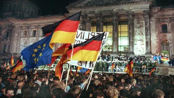 Rund eine Million Menschen feiern in der Nacht zum 03.10.1990 in Berlin wie hier vor dem Reichstagsgebäude die Deutsche Einheit. © dpa / Wolfgang Kumm Foto: Wolfgang Kumm