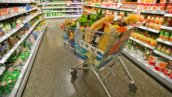 Ein voller Einkaufswagen steht im Gang eines Supermarkts. © Colourbox Foto: PetraD