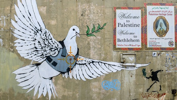 Das Graffiti von Banksy an der Grenzmauer nach Israel zu Bethlehem im Westjordanland zeigt eine Friedenstaube mit schusssicherer Weste © Bildagentur-online/Schöning 