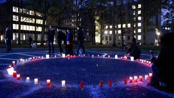 Besucher des Joseph-Carlebach-Platz, auf dem mit Kreide die Grundrisse der Bornplatz-Synagoge, die von den Nationalsozialisten zerstört wurde, aufgemalt sind, zünden Grablichter an. © dpa Foto: Axel Heimken