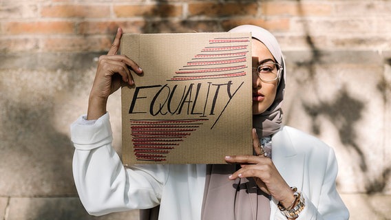 Eine junge Frau hält ein Transparent mit der Aufschrift "Equality". © picture alliance / Westend61 Foto: Xavier Lorenzo