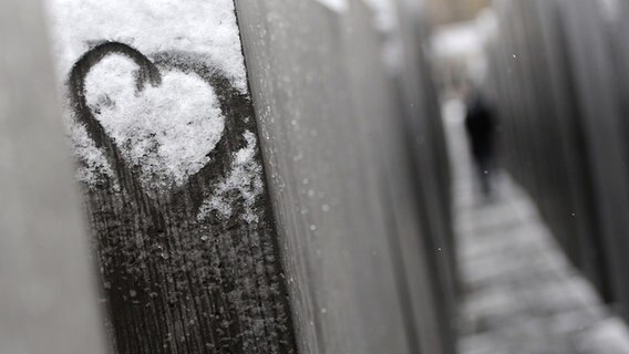 Ein Herz ist am Holocaust-Mahnmal in Berlin in den Schnee gemalt. © picture alliance / ZB Foto: Britta Pedersen