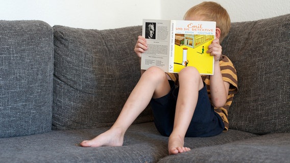 Ein Junge liest im Buch "Emil und die Detektive" von Erich Kästner. © picture alliance / dpa Foto: Anja Garms