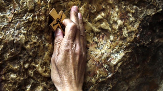 Ein orthodoxer Christ hält am Karfreitag während einer Karfreitagsrozession ein Kreuz in der Hand. © picture alliance/dpa Foto: Mahmoud Illean