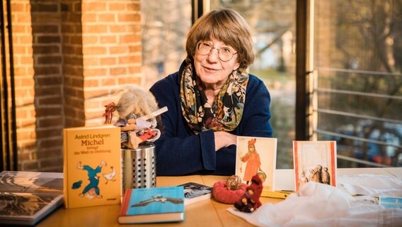 Monika Beier sitzt vor Büchern und Bildern zum Thema Astrid Lindgren © Kirchenkreis Hamburg-Ost Foto: Elfriede Liebenow