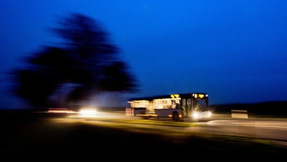 Ein Linienbus fährt in der Abenddämmerung über eine Landstraße. © picture alliance / dpa Foto: Julian Stratenschulte