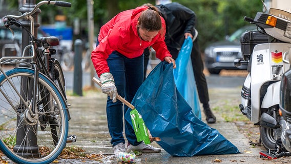 Freiwillige sammeln im Rahmen der Aufräum-Aktion zum World Cleanup Day in der Nähe der Schönhauser Allee Müll von der Straße. © picture alliance/dpa/dpa-Zentralbild Foto: Monika Skolimowska