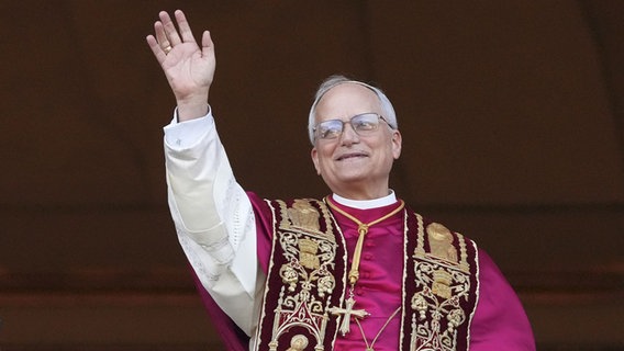 Der neu gewählte Papst Leo XIV., der US-Amerikaner Robert Prevost, winkt nach dem Konklave auf dem Balkon des Petersdoms im Vatikan. © picture alliance/dpa/AP Foto: Alessandra Tarantino