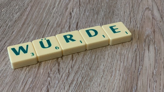 Auf einer Tischoberfläche liegt aus Scrabble-Buchstaben das Wort "Würde". © Kirche im NDR Foto: Christine Raczka