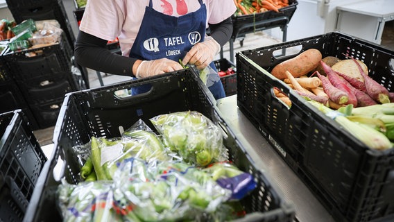 Eine ehrenamtliche Helferin entpackt und sortiert Lebensmittel in der Ausgabestelle der Jungen Tafel am Kolberger Platz in Lübeck. © picture alliance/dpa Foto: Christian Charisius