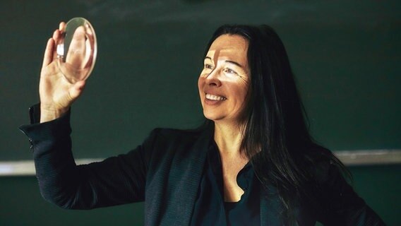 Tatjana Schnell hält ein Brennglas in der Hand © Claudia Mirbach Foto: Claudia Mirbach