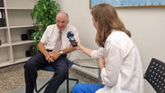 Korrespondentin Charlotte Horn interviewt den Regionalarzt Dr. Volker Klinnert in Neu Delhi © NDR Foto: Peter Hornung
