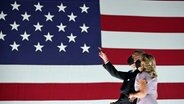 US-Präsidentschaftskandidat Joe Biden mit seiner Frau zeigt auf die Flagge der USA  Foto: Kevin Lamarque