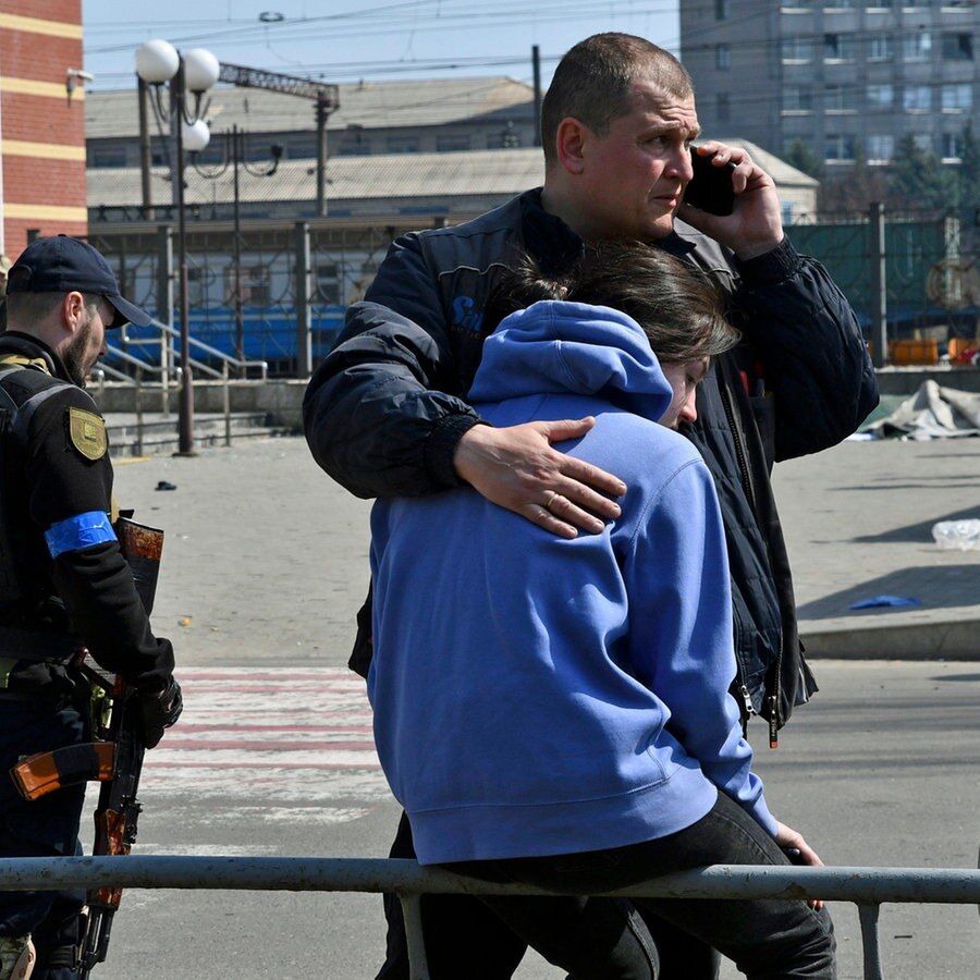 Ein Mann umarmt eine Frau nach russischem Beschuss des Bahnhofs in Kramatorsk. © AP/dpa Foto: Andriy Andriyenko
