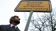 Michel Abdollahi vor dem Ortseingangsschild von Sumte. © NDR / Ralph Baudach 